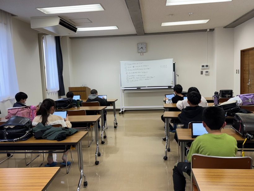 イスに座ってタブレットを触っている